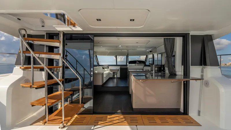 Au Natural Yacht Photos Pics Luxury interior of 2023 Fountaine Pajot MY 6 yacht with modern design and wooden staircase.