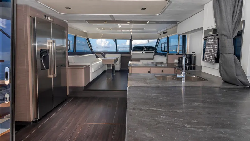 Au Natural Yacht Photos Pics Luxurious interior of 2023 Fountaine Pajot MY 6 yacht with modern kitchen and seating area.