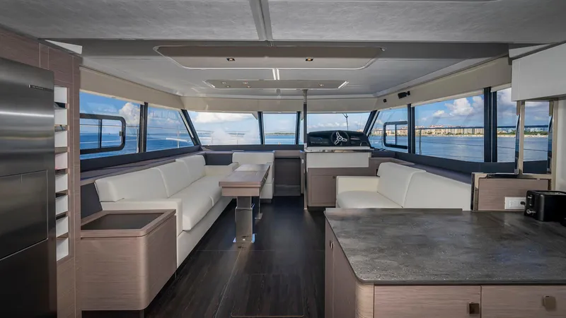 Au Natural Yacht Photos Pics Luxurious interior of 2023 Fountaine Pajot MY 6 yacht with panoramic windows and modern furnishings.