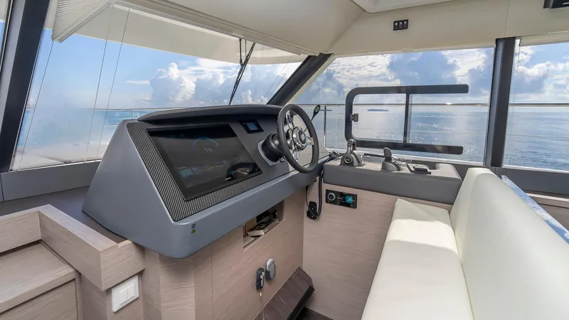 Au Natural Yacht Photos Pics Interior helm of 2023 Fountaine Pajot MY 6 yacht with modern controls and ocean view.