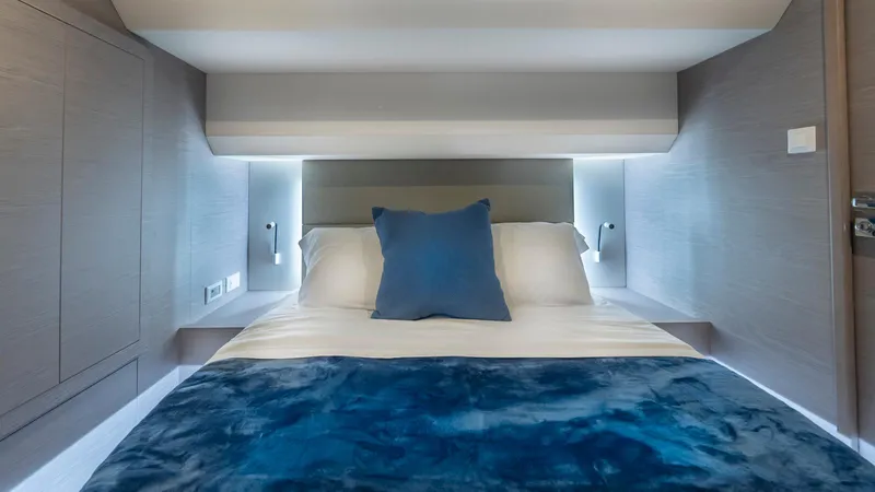 Au Natural Yacht Photos Pics Luxurious bedroom interior of 2023 Fountaine Pajot MY 6 yacht with blue accents.