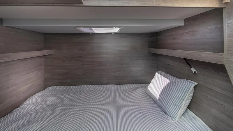 Au Natural Yacht Photos Pics Cozy cabin interior of 2023 Fountaine Pajot MY 6 yacht with wood paneling and bedding.