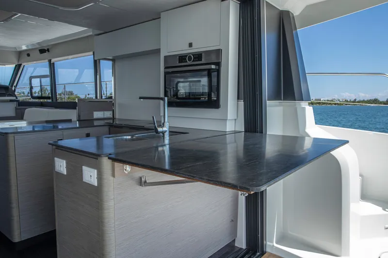 Au Natural Yacht Photos Pics Modern kitchen interior of 2023 Fountaine Pajot MY 6 yacht with ocean view.
