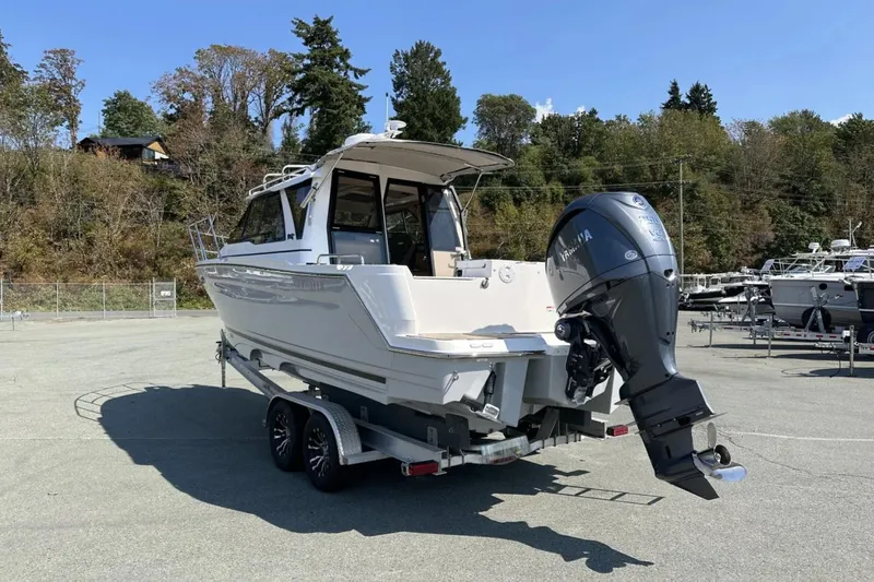  Yacht Photos Pics 2026 Cutwater C-248 Coupe boat on trailer, parked outdoors with trees in background.