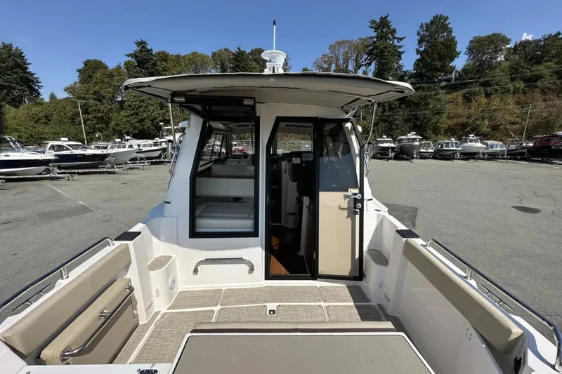  Yacht Photos Pics 2026 Cutwater C-248 Coupe boat interior, docked with open cabin door, surrounded by trees.