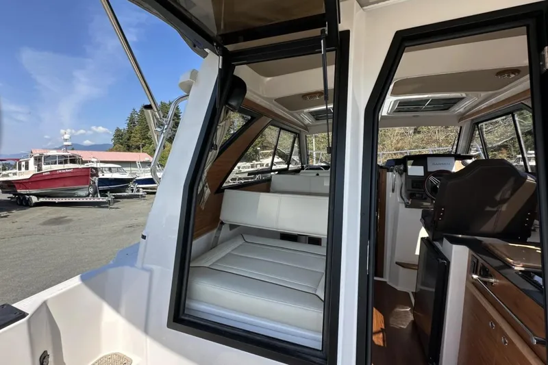  Yacht Photos Pics 2026 Cutwater C-248 Coupe interior with seating and helm, docked near other boats.