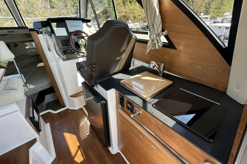  Yacht Photos Pics 2026 Cutwater C-248 Coupe interior with helm, kitchenette, and wood accents.