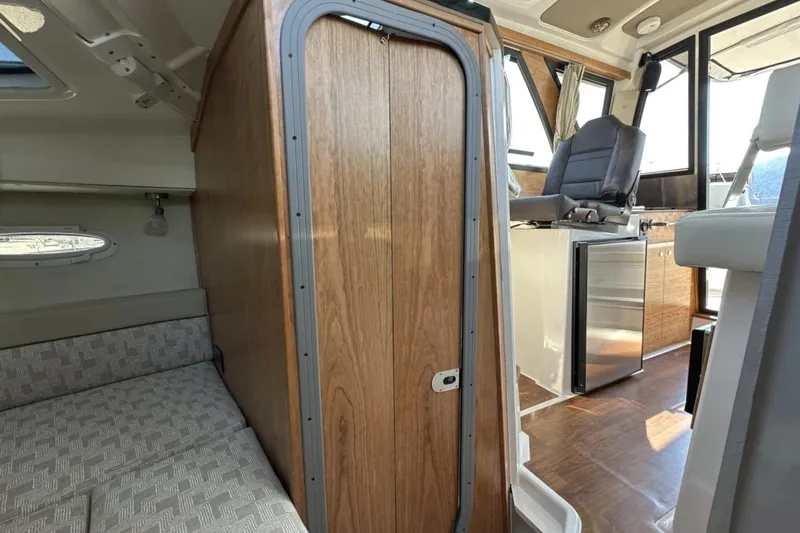  Yacht Photos Pics Interior of 2026 Cutwater C-248 Coupe, featuring seating, wood paneling, and compact kitchenette.