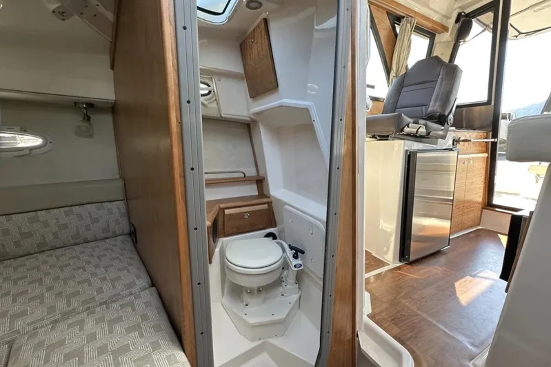  Yacht Photos Pics 2026 Cutwater C-248 Coupe interior with compact bathroom, seating, and kitchenette.