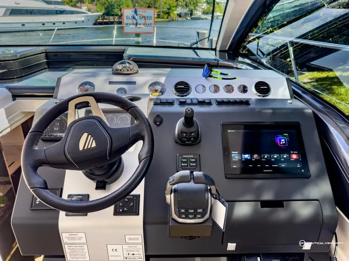  Yacht Photos Pics Control panel of a 2023 Fairline Targa 45 Open yacht with steering wheel and touchscreen display.