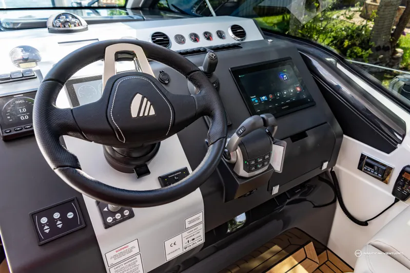 Yacht Photos Pics 2023 Fairline Targa 45 Open yacht helm with steering wheel and touchscreen controls.