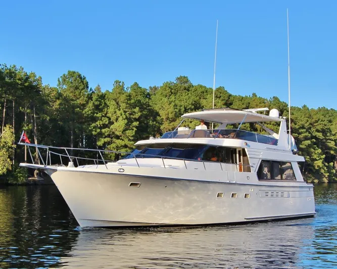 Slainte Yacht Photos Pics 1992 Tollycraft 53 Motor Yacht cruising on a serene lake with forest backdrop.