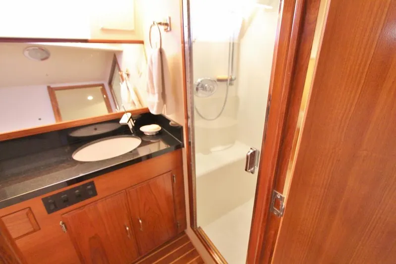Slainte Yacht Photos Pics Luxurious bathroom in 1992 Tollycraft 53 Motor Yacht with wood cabinetry and glass shower.