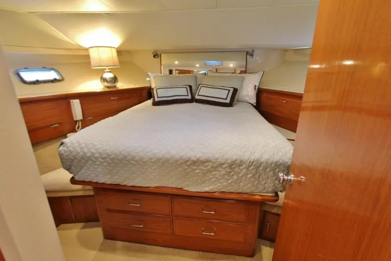 Slainte Yacht Photos Pics Luxurious bedroom interior of 1992 Tollycraft 53 Motor Yacht with elegant wood finish.