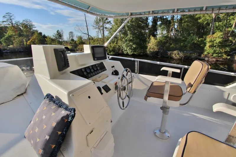 Slainte Yacht Photos Pics 1992 Tollycraft 53 Motor Yacht helm with steering wheel, controls, and cushioned seating.