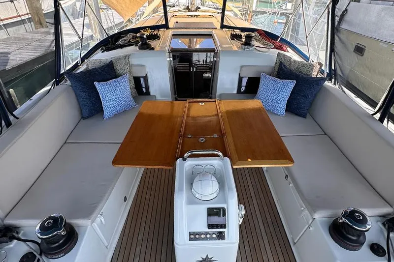 Nautical Dreamer Yacht Photos Pics 2019 Jeanneau Sun Odyssey 490 cockpit with cushioned seating and wooden table.