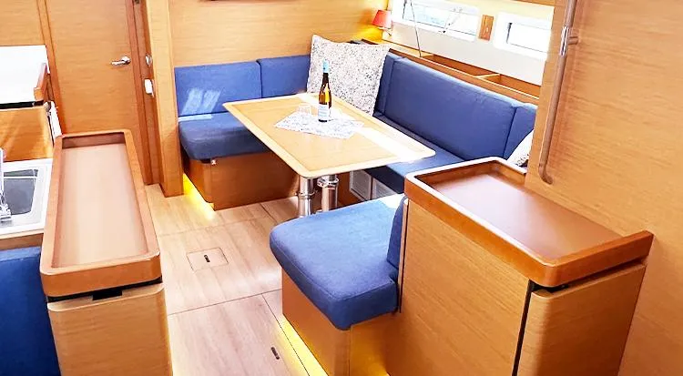 Nautical Dreamer Yacht Photos Pics Interior of 2019 Jeanneau Sun Odyssey 490 yacht with blue seating and wooden finishes.