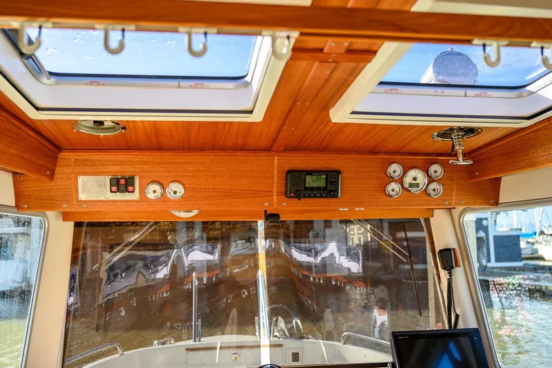  Yacht Photos Pics Interior view of 2019 Targa 27.2 boat cockpit with wooden paneling and navigation instruments.