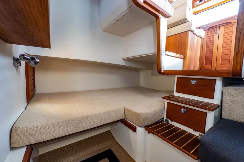  Yacht Photos Pics 2019 Targa 27.2 boat interior with wooden steps and cozy sleeping area.