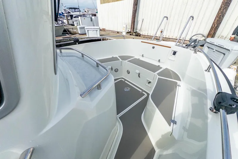  Yacht Photos Pics 2019 Targa 27.2 boat deck with seating and storage at a marina.