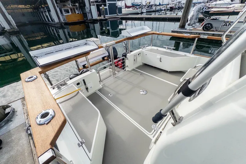  Yacht Photos Pics 2019 Targa 27.2 boat deck with wooden railings in a marina setting.