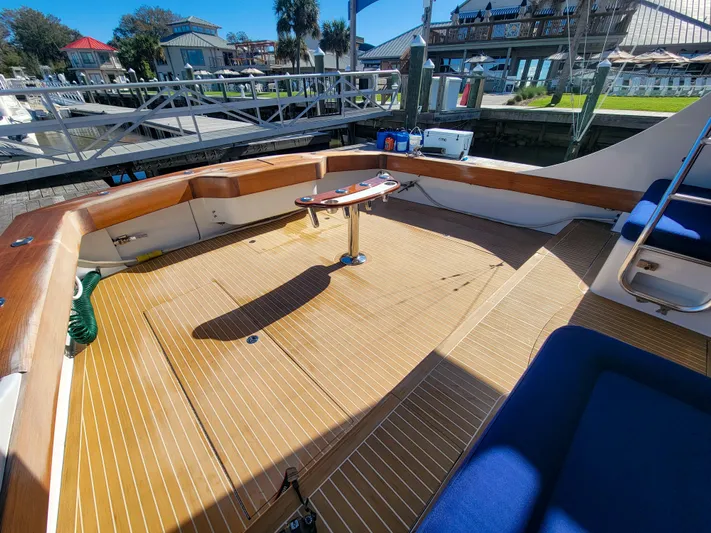  Yacht Photos Pics 2005 Custom Carolina 66 boat deck with wooden flooring and seating at a marina.