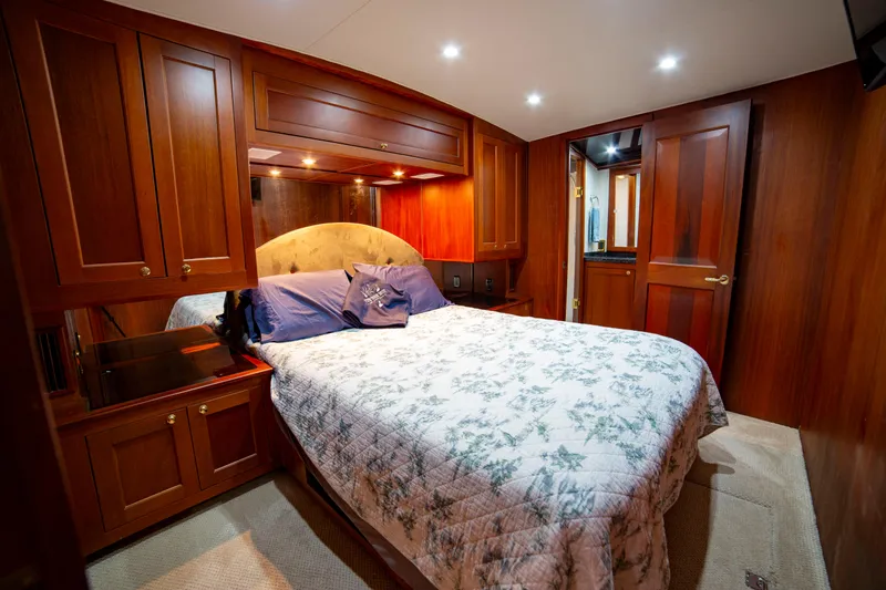  Yacht Photos Pics Luxurious bedroom interior of 2005 Custom Carolina 66 yacht with wooden cabinetry and cozy bedding.