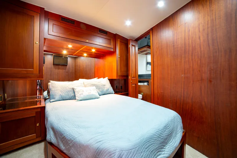  Yacht Photos Pics Luxurious bedroom in 2005 Custom Carolina 66 yacht with wood paneling and cozy bedding.