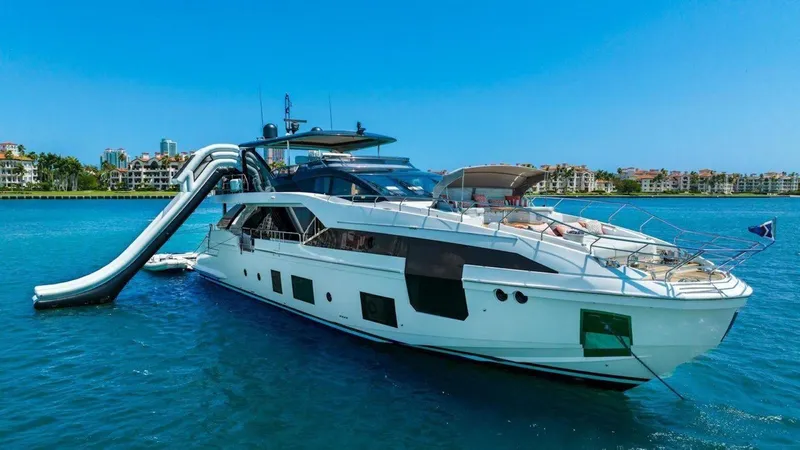 Enchante Yacht Photos Pics Luxury Azimut Grande 27 METRI yacht with slide, 2020 model, on clear blue water.