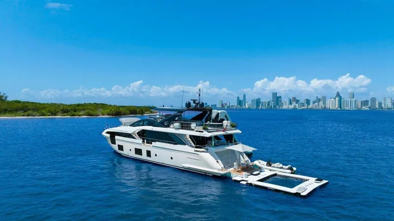 Enchante Yacht Photos Pics Luxurious 2020 Azimut Grande 27 METRI yacht on serene blue waters near city skyline.