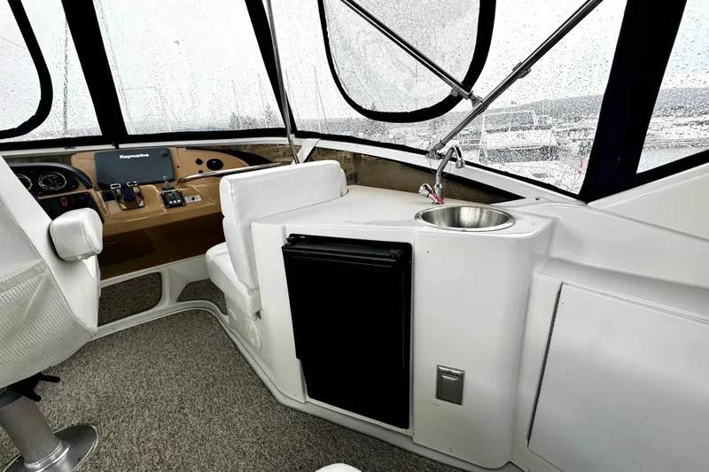  Yacht Photos Pics 2003 Carver 396 Motor Yacht helm with controls, sink, and seating in rainy weather.