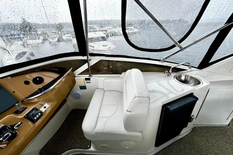  Yacht Photos Pics 2003 Carver 396 Motor Yacht interior with helm, white seating, and sink, overlooking marina.