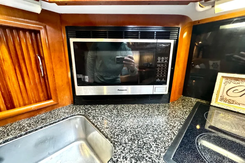  Yacht Photos Pics 2003 Carver 396 Motor Yacht kitchen with microwave, granite countertop, and sink.
