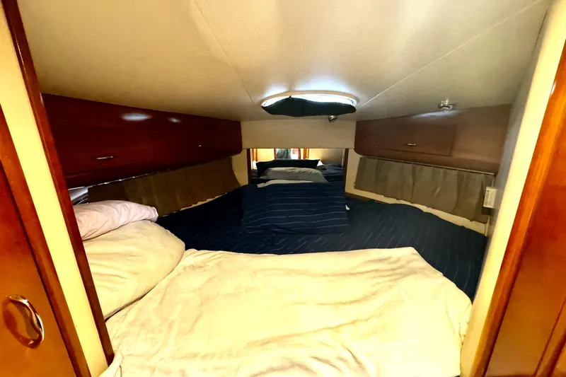  Yacht Photos Pics Interior cabin of 2003 Carver 396 Motor Yacht with cozy bedding and wooden cabinets.