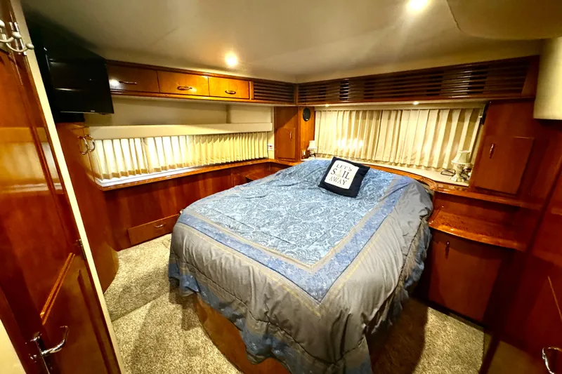  Yacht Photos Pics Luxurious bedroom in 2003 Carver 396 Motor Yacht with cozy bedding and elegant wood finishes.