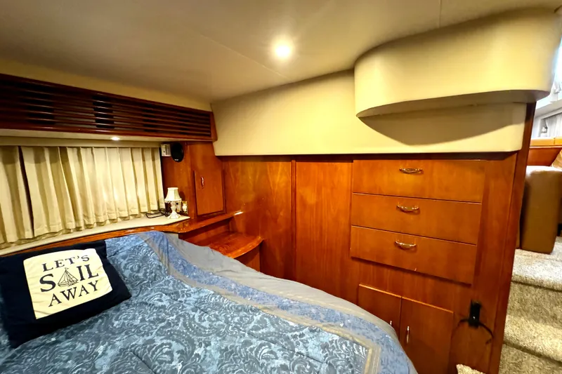  Yacht Photos Pics Luxurious 2003 Carver 396 Motor Yacht bedroom with wood cabinetry and cozy bedding.