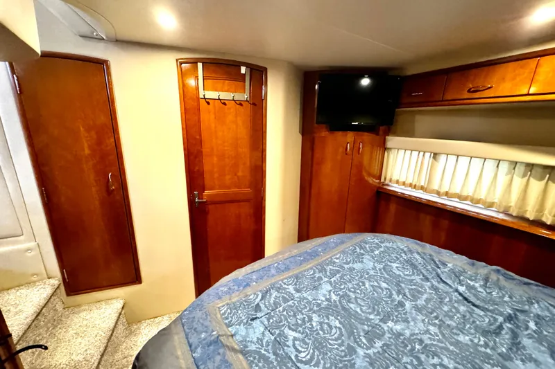  Yacht Photos Pics 2003 Carver 396 Motor Yacht interior with wood cabinetry, bed, and TV.