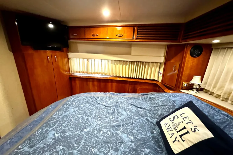  Yacht Photos Pics Luxurious 2003 Carver 396 Motor Yacht bedroom with elegant wood cabinetry and cozy bedding.