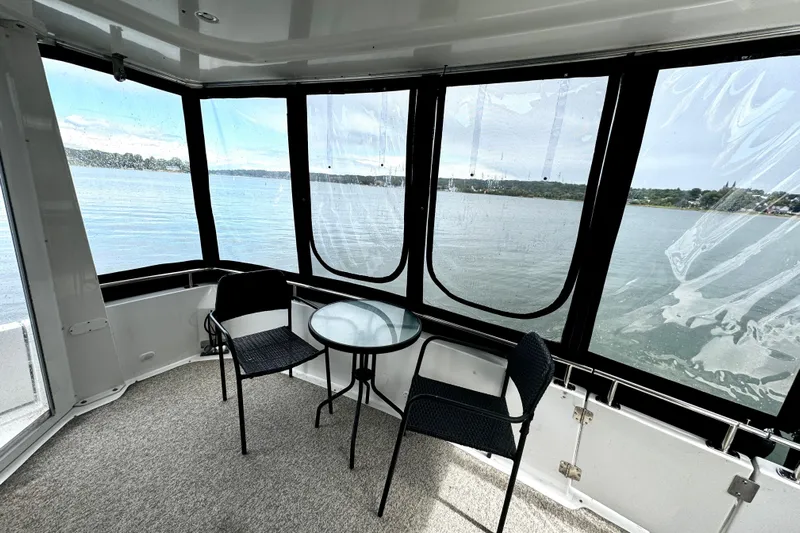  Yacht Photos Pics 2003 Carver 396 Motor Yacht interior with lake view, featuring chairs and a glass table.
