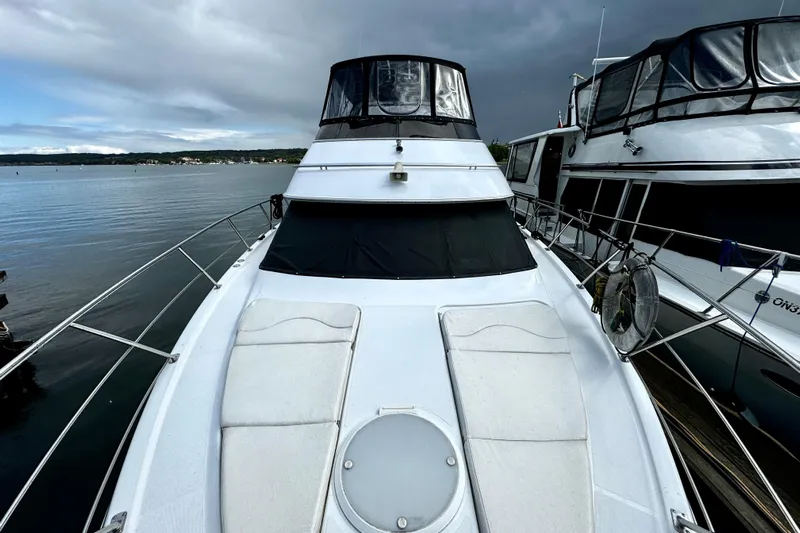  Yacht Photos Pics 2003 Carver 396 Motor Yacht docked on a calm lake under cloudy skies.
