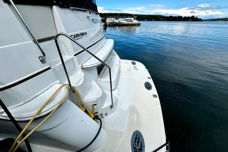  Yacht Photos Pics 2003 Carver 396 Motor Yacht docked by calm waters, showcasing rear deck and steps.