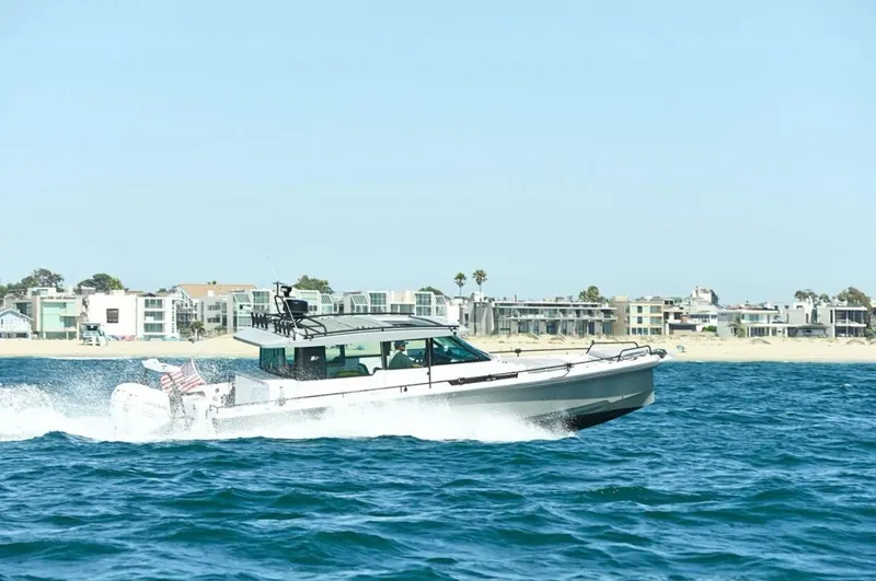 Problem Child Yacht Photos Pics 2017 Axopar 37 Cross Cabin boat cruising near coastal buildings.