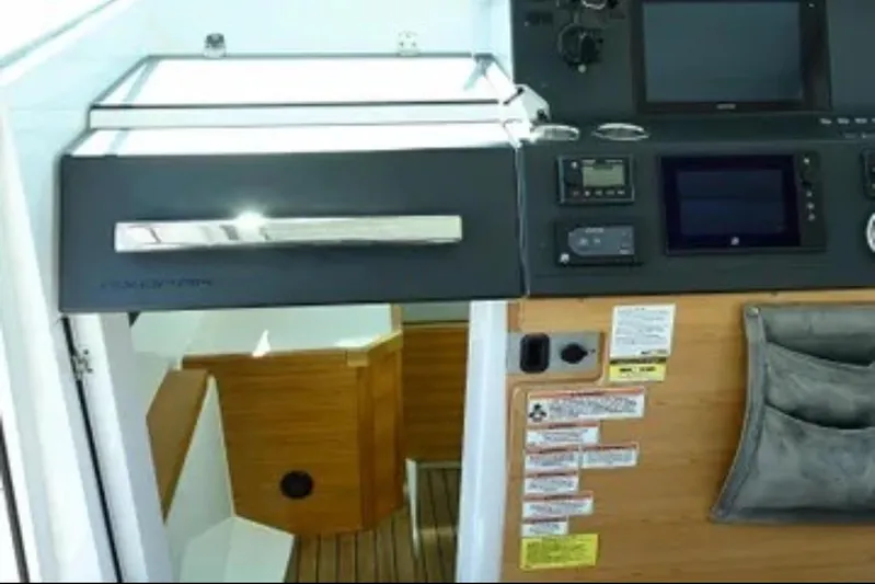 Problem Child Yacht Photos Pics Interior view of 2017 Axopar 37 Cross Cabin, featuring control panel and wooden stairs.