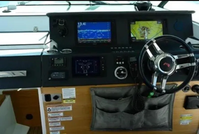 Problem Child Yacht Photos Pics Control panel of 2017 Axopar 37 Cross Cabin with navigation screens and steering wheel.