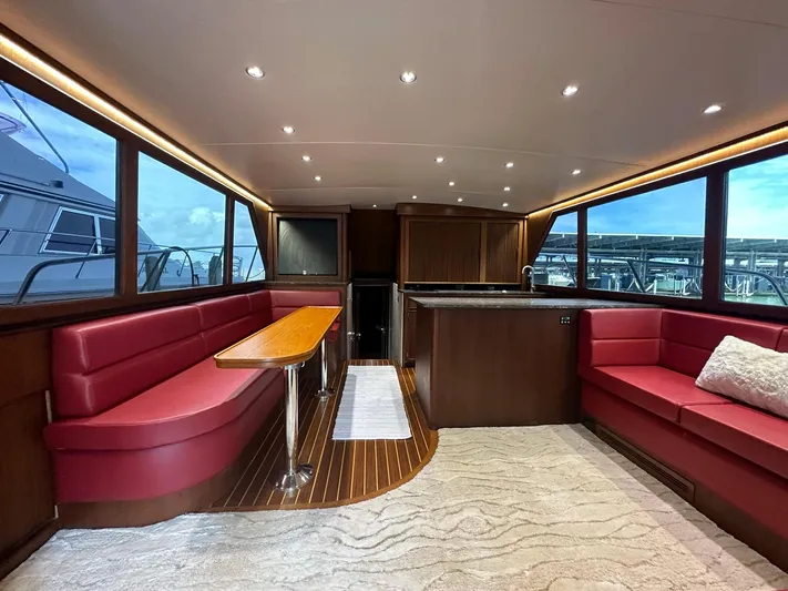 The Godfather Yacht Photos Pics Luxurious interior of 1986 Hatteras 52 Convertible yacht with red seating and wood accents.