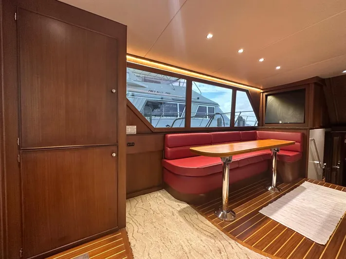 The Godfather Yacht Photos Pics Interior of 1986 Hatteras 52 Convertible yacht with red seating and wooden finishes.
