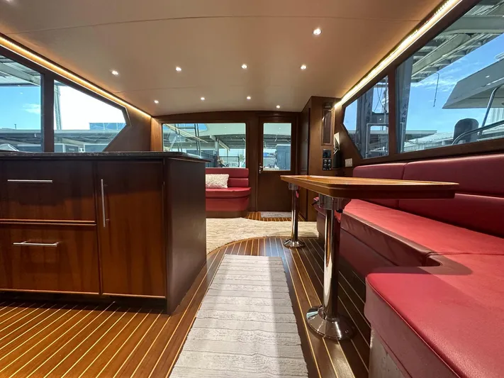 The Godfather Yacht Photos Pics Luxurious interior of 1986 Hatteras 52 Convertible yacht with wood finishes and red seating.