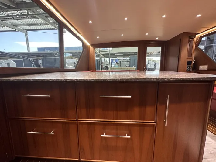 The Godfather Yacht Photos Pics Interior of 1986 Hatteras 52 Convertible yacht with wooden cabinetry and marble countertop.