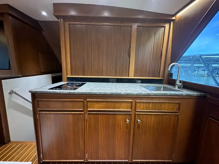 The Godfather Yacht Photos Pics Interior of 1986 Hatteras 52 Convertible yacht with wooden cabinetry and granite countertop.