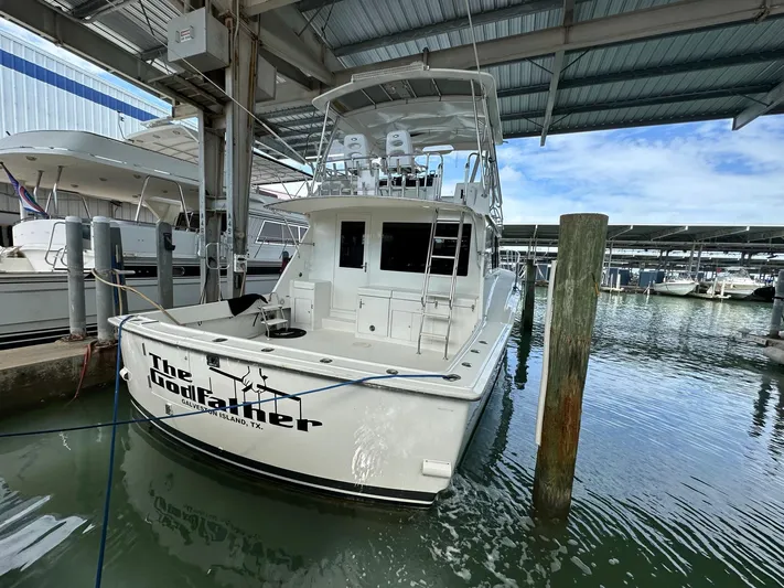 The Godfather Yacht Photos Pics 1986 Hatteras 52 Convertible yacht docked in marina under covered shelter.
